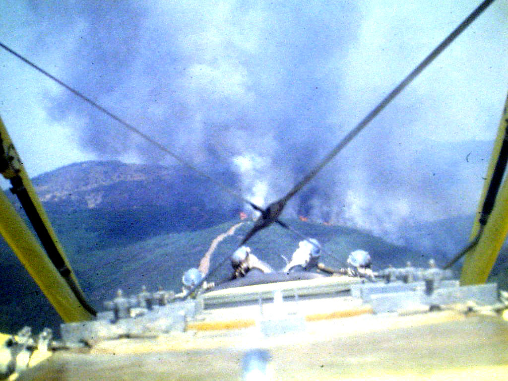 Vista frontal desde la cabina del biplano: el incendio en la ladera más allá del motor